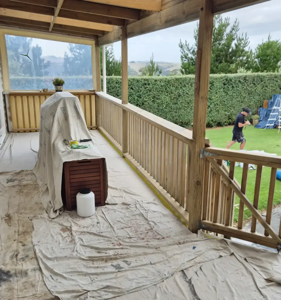 a deck covered in painters cloths to protect areas not being painted