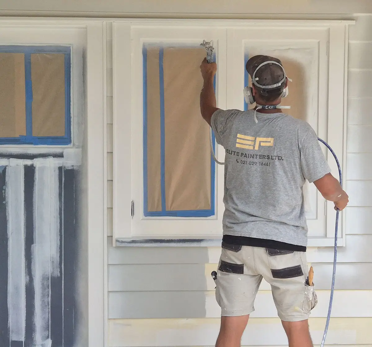 An Elite Painters team member preparing an exterior paint job