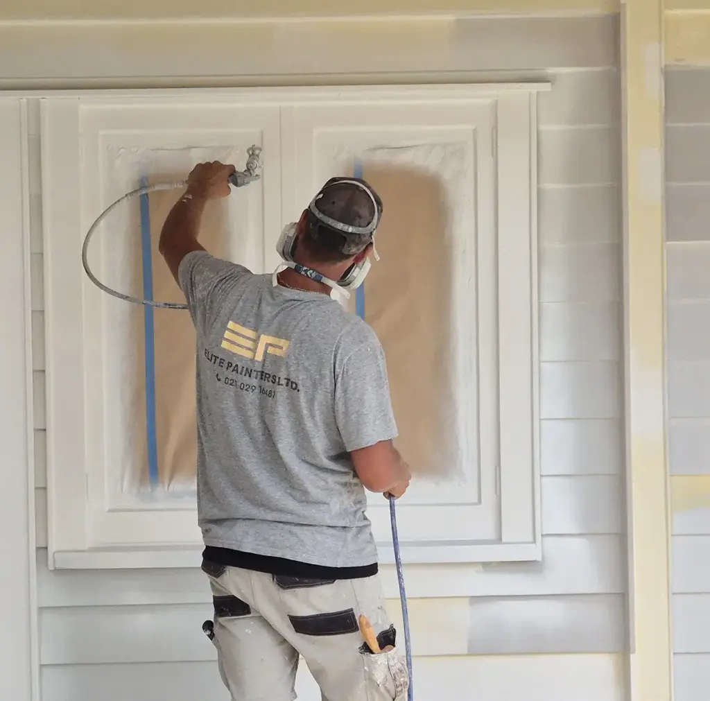 An Elite Painters team member preparing an exterior paint job