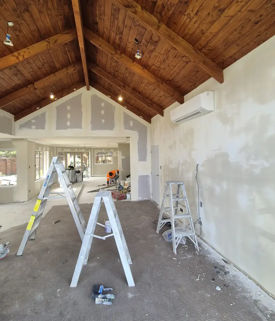 View of a large living area, with plaster on the walls, in preparation for a new paint job